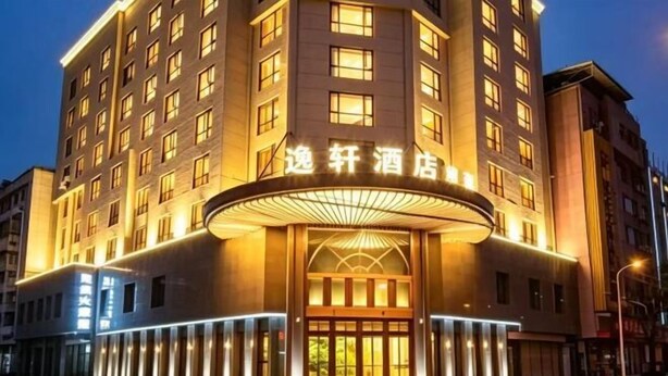 A hotel with a prominent entrance, multiple floors, and a well-lit facade. - Xierdun Yixuan Hotel (Lishui)