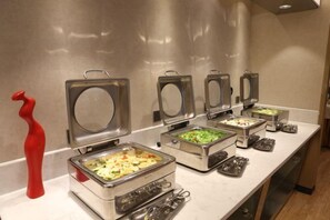 A buffet setup with multiple food dispensers and utensils. - Xierdun Yixuan Hotel (Lishui)