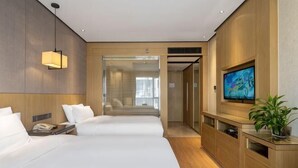 A hotel room with two beds, a TV, a desk, and a plant. - Xierdun Yixuan Hotel (Lishui)