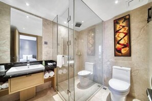 Un baño moderno con ducha acristalada, lavabo blanco y retrete.