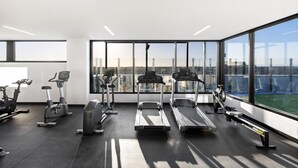 Un gimnasio moderno con cintas de correr, elípticas y bicicletas estáticas.