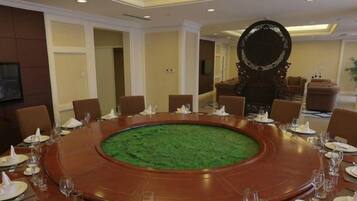 A conference room with a round table, chairs, and a decorative mirror.
