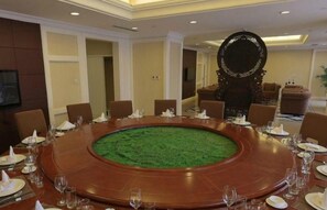 A conference room with a round table, chairs, and a decorative mirror. - Luanzhou International Hotel (Tangshan)
