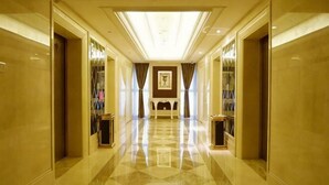 A corridor with a polished floor, a central light fixture, and a framed artwork on the wall. - Luanzhou International Hotel (Luanzhou)