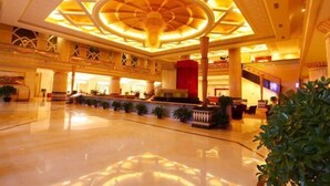 A spacious lobby with a central atrium, multiple seating areas, and a reception desk. - Luanzhou International Hotel (Luanzhou)