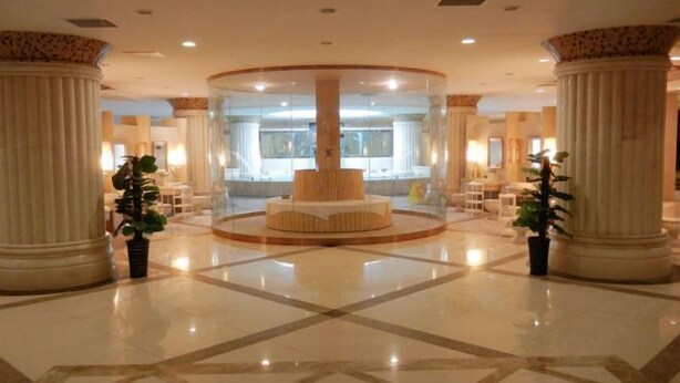 A lobby with a central circular seating area, large columns, and a polished floor. - Luanzhou International Hotel (Luanzhou)