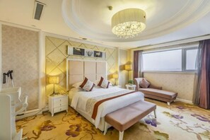 A hotel room with a large bed, a bench, a bedside table, a nightstand, a chandelier, and a window with curtains. - Luanzhou International Hotel (Tangshan)