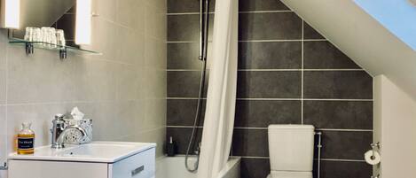 Ein modernes Badezimmer mit Badewanne, Toilette und Waschtisch.
