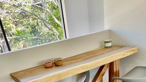 Un pequeño bar moderno con mostrador de madera y tres taburetes.