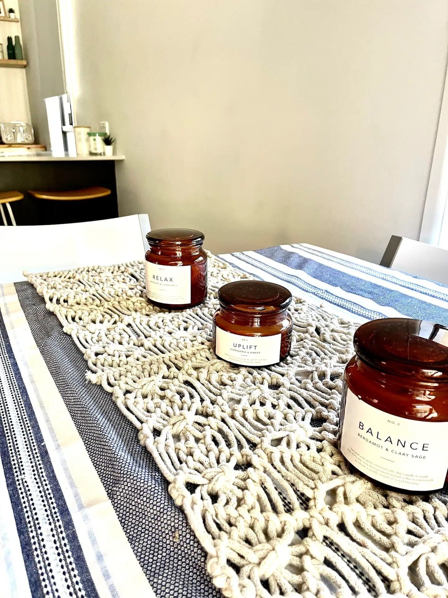 A table with three candles on a woven placemat.