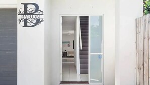 Una casa moderna con fachada blanca, puerta de garaje y cerca de madera.