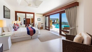 Ein geräumiges Schlafzimmer mit einem großen Bett, einem Schreibtisch und Blick auf ein Schwimmbad und Berge.