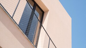 Eine Gebäudefassade mit einem Fenster und einem Balkongeländer.