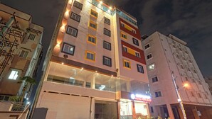 Un hotel de varios pisos con un letrero llamativo que dice "HOTEL PRIME BLISS".