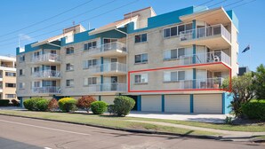 A multi-story residential building with balconies, a garage, and a clear sky. - Unit 1 Seascapes Golden Beach Waterfront Balcony (Golden Beach)