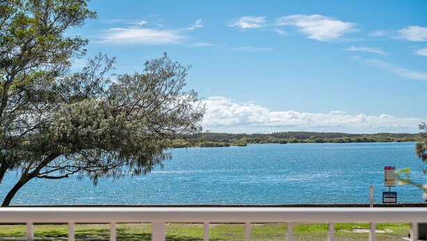 A lake with a tree in the foreground and a clear sky. - Unit 1 Seascapes Golden Beach Waterfront Balcony (Golden Beach)