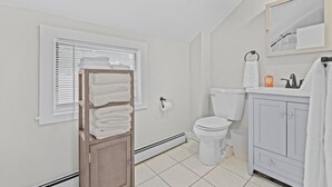 Een badkamer met toilet, wastafel en handdoekhouder.