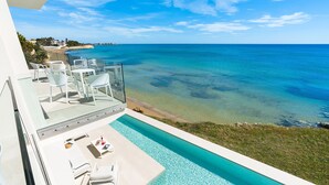 A modern hotel balcony with a clear view of the ocean and a swimming pool. - Luxury sea front villa with pool, Lido di Noto, Sicily (Noto)