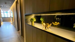 A hallway with a reception desk, wooden flooring, and a plant on the counter. - ST Signature Tanjong Pagar, DAYUSE, 8 hours: 10AM-6PM (Singapore)