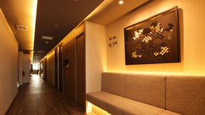 A hallway with a bench, wooden flooring, and a wall-mounted light fixture. - ST Signature Tanjong Pagar, DAYUSE, 8 hours: 10AM-6PM (Singapore)