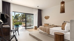 A modern bedroom with a large bed, a desk, and a view of a pool and greenery. - Balmy Beach Resort Kemer (Kemer)
