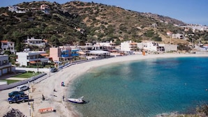 A coastal town with a beach, buildings, and a hilly backdrop. - Steliana's House Top Floor Apartment with Private Jacuzzi (Ligaria)