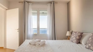 A hotel room with a bed, a nightstand, a lamp, and a window with curtains. - Steliana's House Top Floor Apartment with Private Jacuzzi (Ligaria)