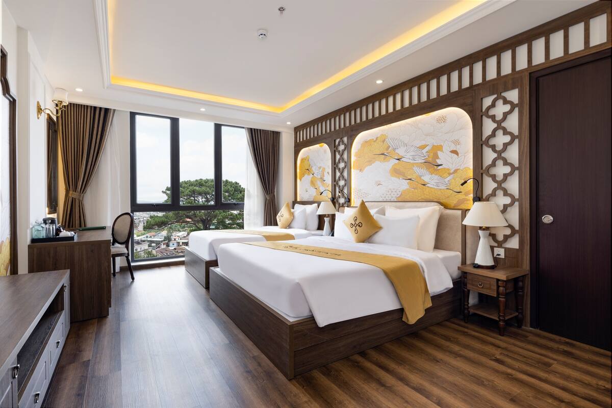 Ein modernes Hotelzimmer mit einem großen Bett, einem Schreibtisch und Blick auf die Stadt.
