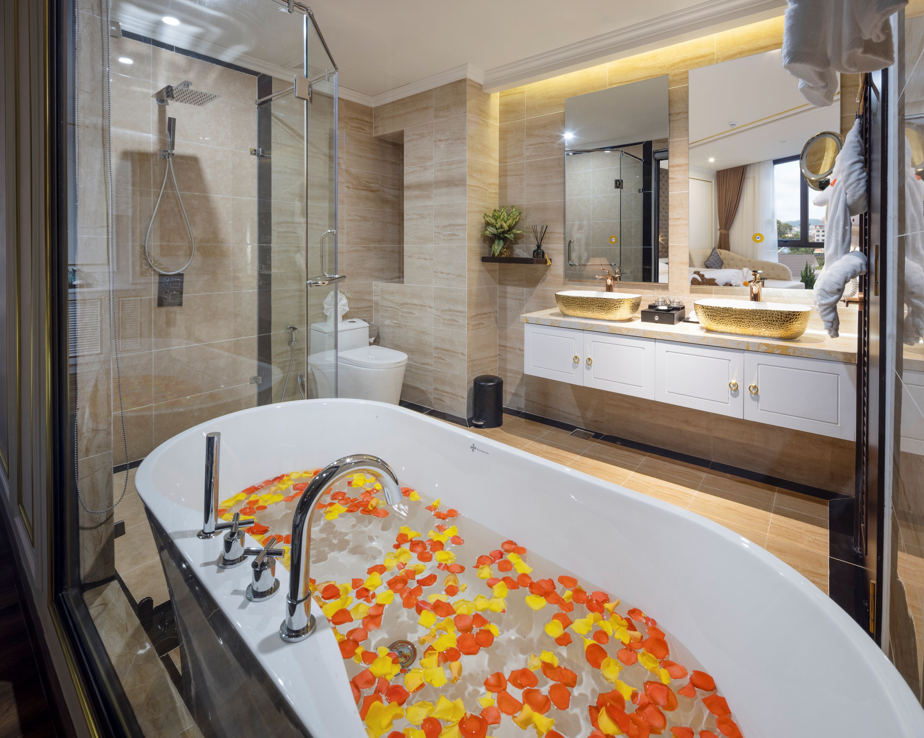 A modern bathroom with a freestanding bathtub, a glass-enclosed shower, and a vanity with a large mirror.
