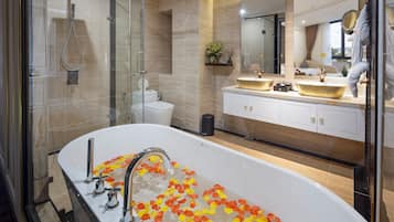 A modern bathroom with a freestanding bathtub, a glass-enclosed shower, and a vanity with a large mirror.