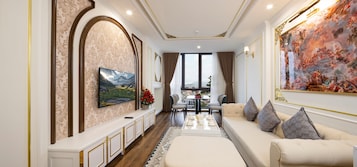 Un salón amplio con un sofá grande, una mesa de comedor y un cuadro en la pared.