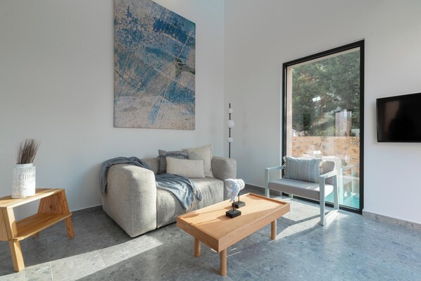 A modern living room with a sofa, coffee table, and a large abstract painting on the wall.
