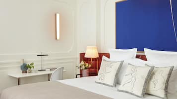 Een hotelkamer met een groot bed, een bureau met een lamp en uitzicht op de stad.