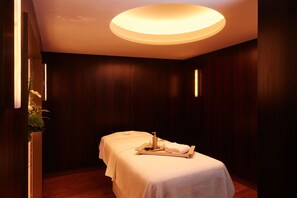 A spa room with two beds, a tray with toiletries, and a ceiling light. - Villa-des-Prés (Paris)