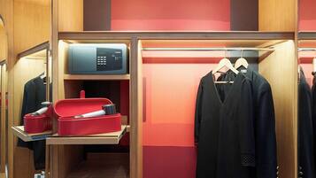 A compact, well-organized closet with mirrored doors, a microwave, and neatly arranged clothing and accessories.