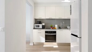 A modern kitchen with white cabinetry, a microwave, a coffee maker, and a sink. - Vacation Home 'Suite Deluxe Puerto Rico 11' with Shared Pool and Wi-Fi (Puerto Rico)