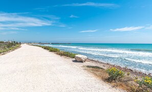 Una carretera costera con vistas despejadas al océano y un muelle distante.