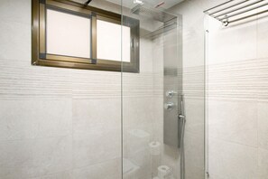 A glass-enclosed shower with a control panel, a window, and a towel rack.