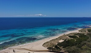 A beach with clear turquoise waters, a sandy shore, and some greenery. - Villa "Finesse Tipo 2" with Private Pool, 2 Private Terraces & Wi-Fi (Son Bou)