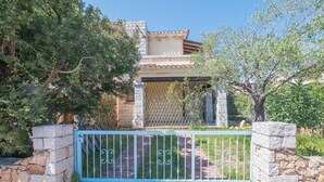A stone building with a tiled roof, a metal gate, and a stone wall. - Holiday Home 'Villetta Sarda' with Private Terrace and Air Conditioning (san teodoro lu fraili)