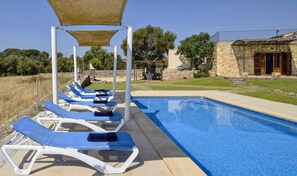 A swimming pool with lounge chairs and a pergola structure. - Holiday Home 'Can Mascaro' with Mountain View, Wi-Fi and Air Conditioning (Manacor)