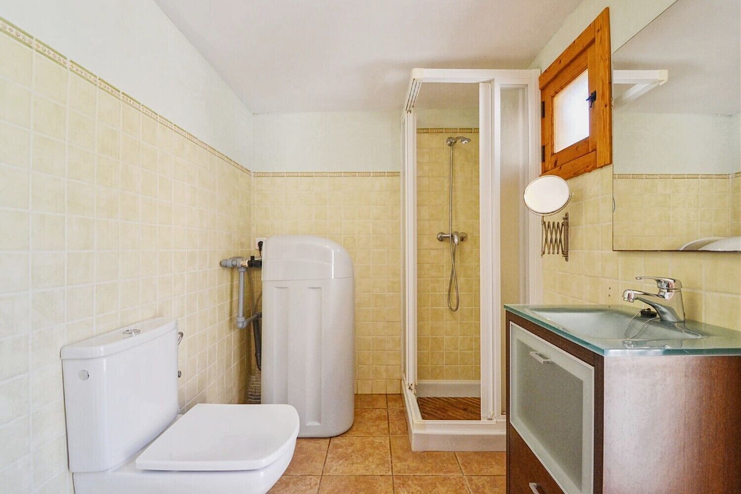 A bathroom with a toilet, a shower, and a sink.