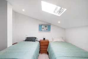 A bedroom with two beds, a nightstand, a lamp, a ceiling light, and a wall-mounted picture. - Apartment 'Bellaë Holiday - California' with Shared Terrace, Shared Garden and Wi-Fi (Apúlia)