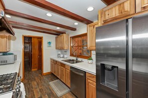 Una cocina moderna con armarios de madera, electrodomésticos de acero inoxidable y lavavajillas integrado.