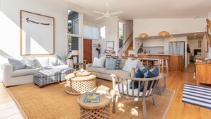 Un salon spacieux avec un grand canapé, une table basse et un coin repas doté de chaises en bois.