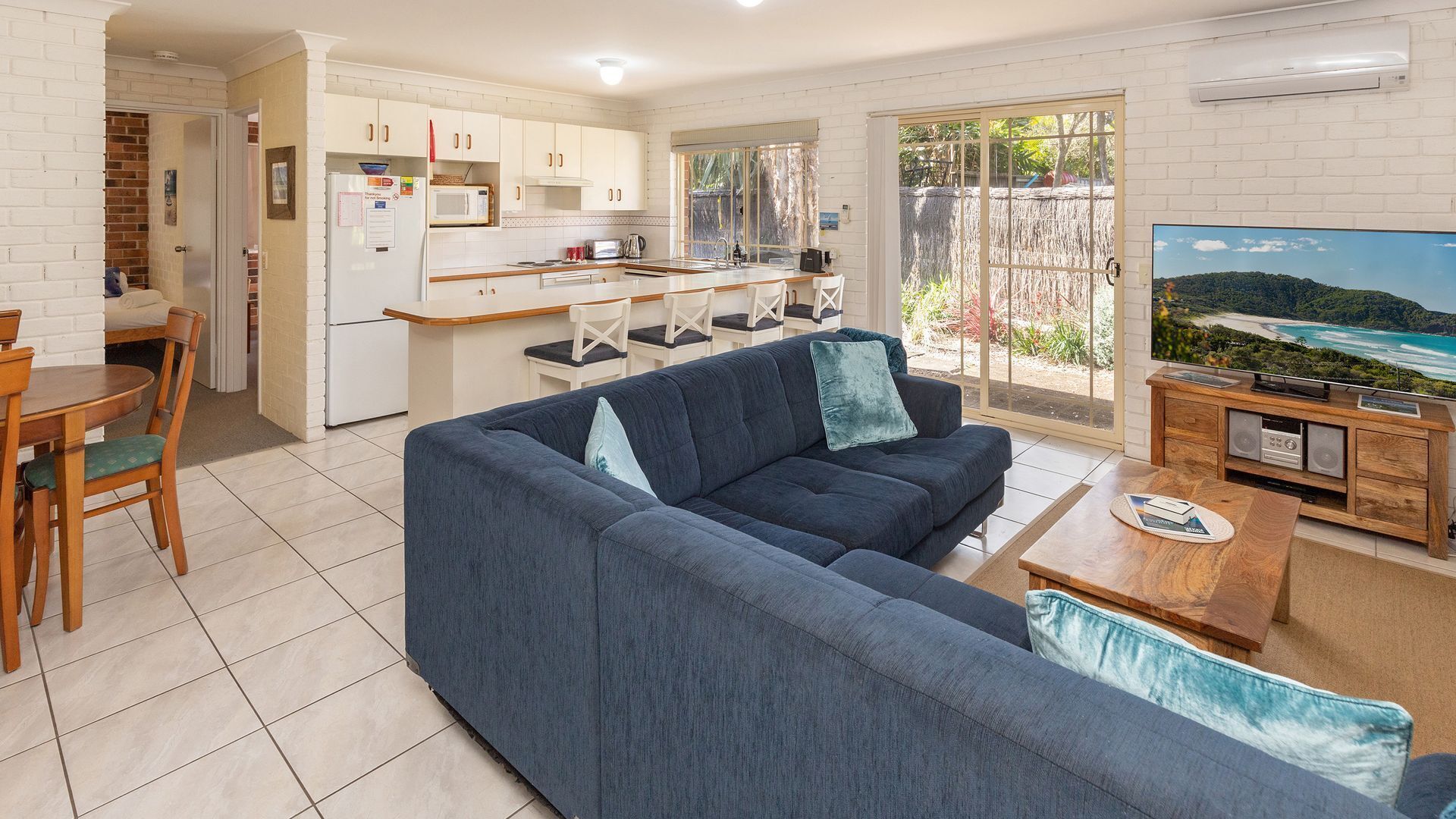 A modern living room with a sofa, TV, and wooden coffee table.