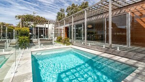 A modern house with a swimming pool, large windows, and a pergola. - Boof's at Blueys Beach (Blueys Beach)