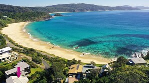 A coastal property with a beach, a road leading to the beach, and several houses with solar panels. - Far Shore @ Seal Rocks (Seal Rocks)