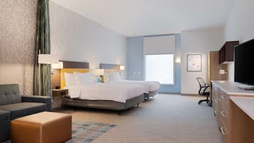 A hotel room with a bed, a desk, a chair, and a television.