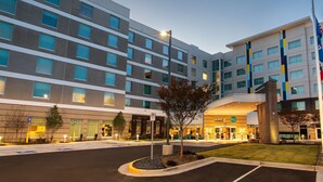A multi-story hotel with a modern design, featuring a prominent entrance with a glass facade and a vertical column with colorful panels. - Tru By Hilton Atlanta Airport College Park (College Park)